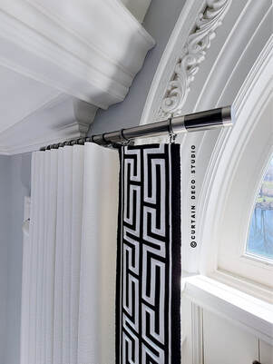 Detailed image of the new classic curtain rod in Alpine, NJ, adorned with white curtains and a black geometric trim, showcasing the refined blend of modern and classic design elements.