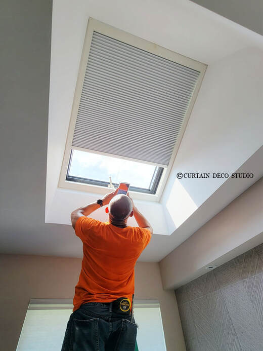 Worker installing a cellular shade on a skylight in Closter, NJ, enhancing energy efficiency and light control.