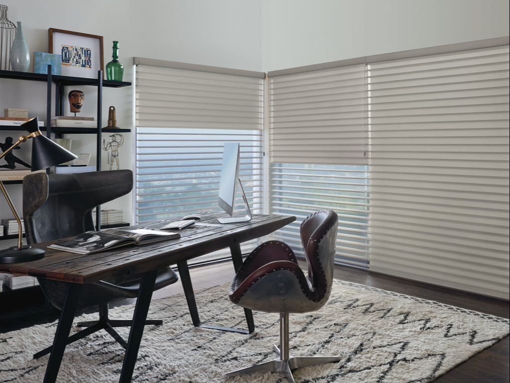 Contemporary home office with beige horizontal blinds, wooden desk, and stylish chair
